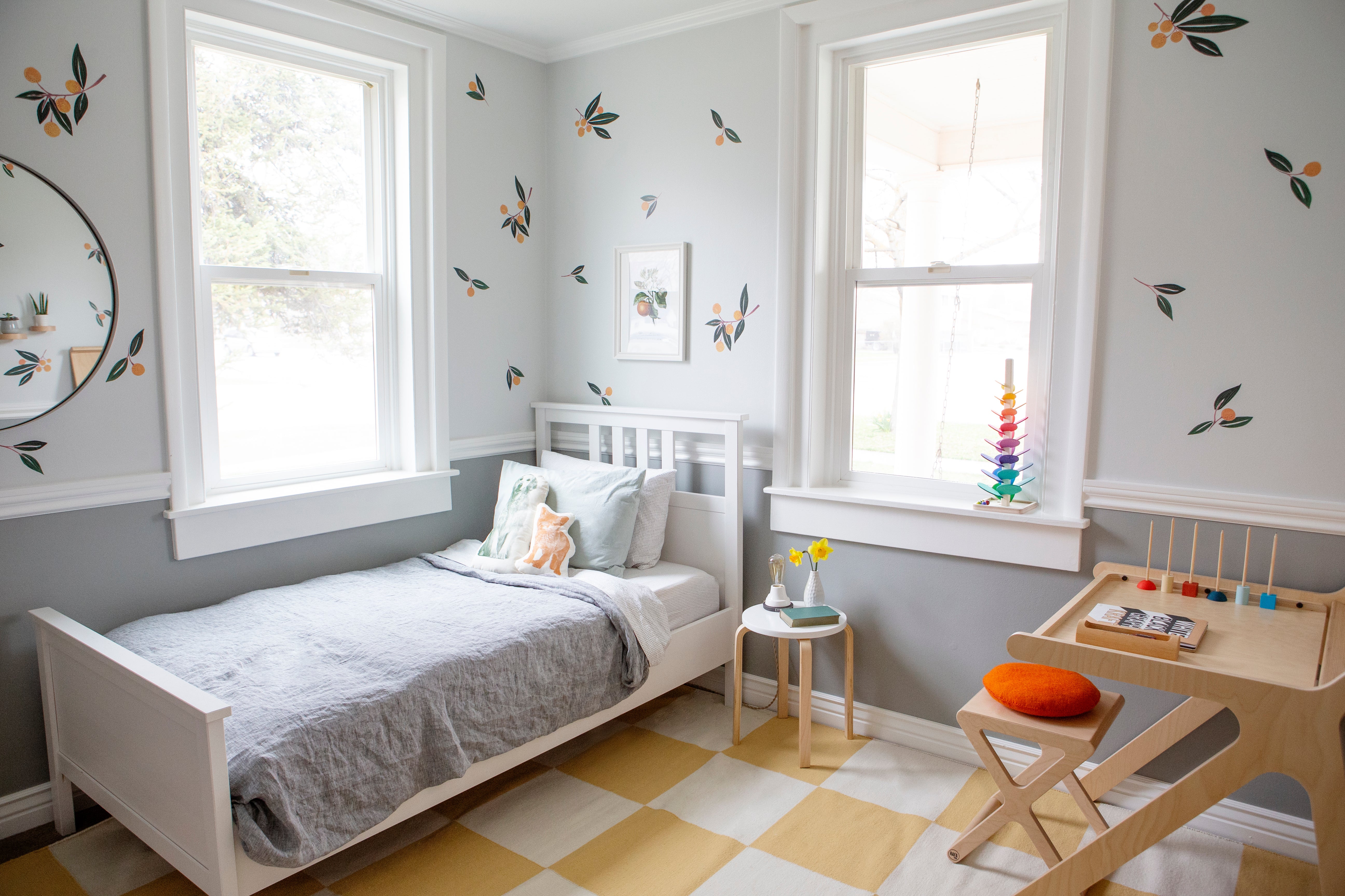 bedroom with a bed with a gray blanket and a small child's desk