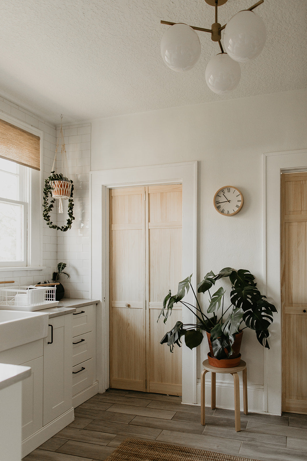 kitchen with a clock on the wall above a potted plant