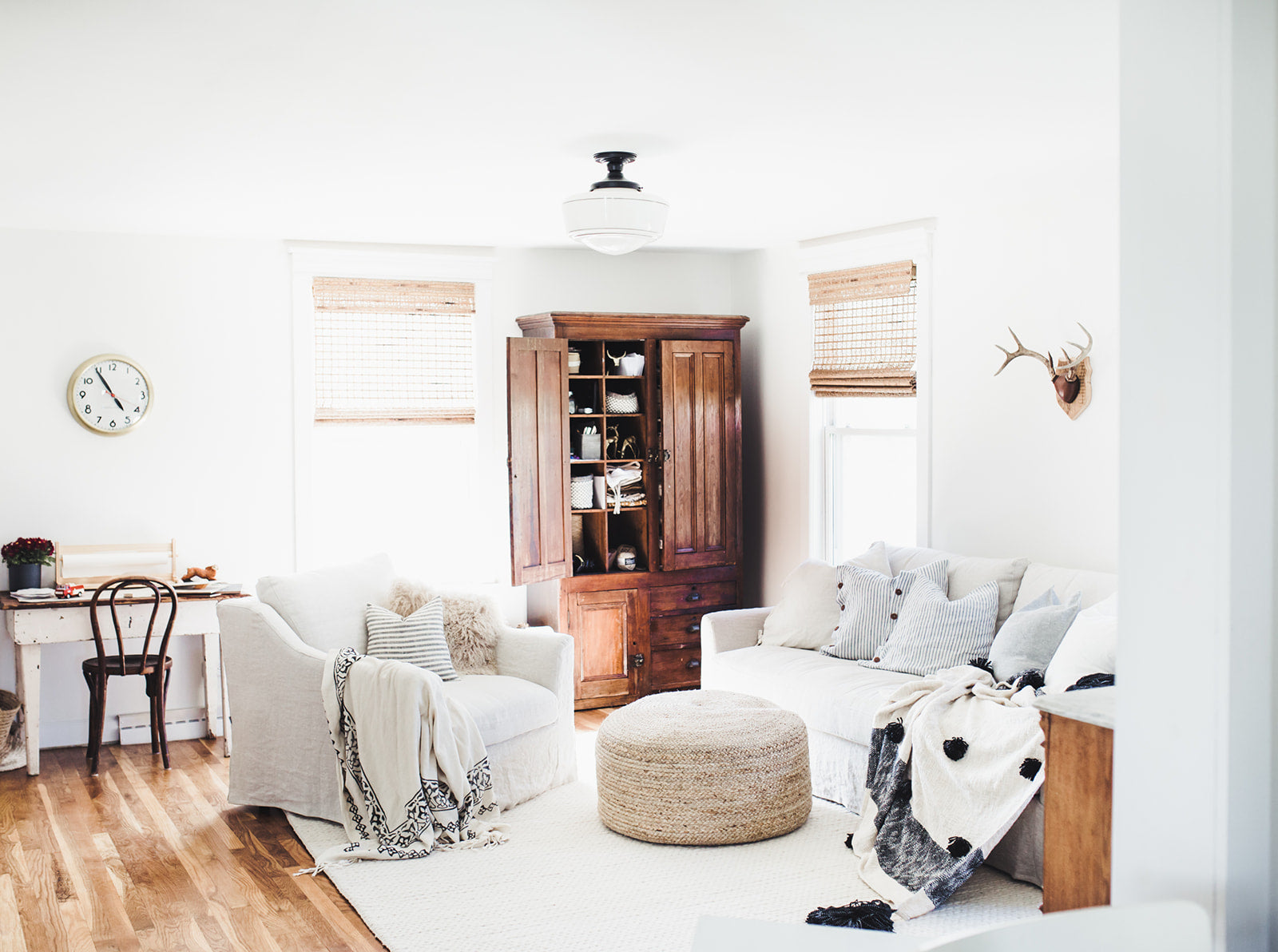 living room with a white couch and a wood cabinet and an ottoman