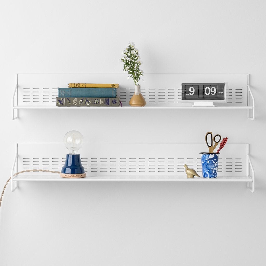 white shelves with books and a lamp on it