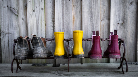 Bobbi Gumboots by Merry People sitting on a shoe rack.