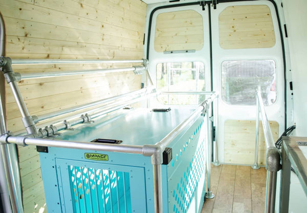 teal stationary impact dog crate as bed in conversion van