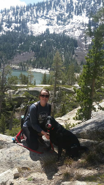 girl and dog hiking to top of mountain