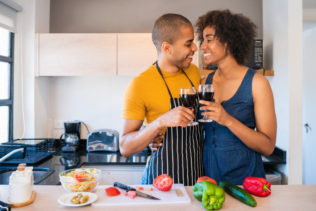 Vegan and omnivore couple cooking together in the kitchen.