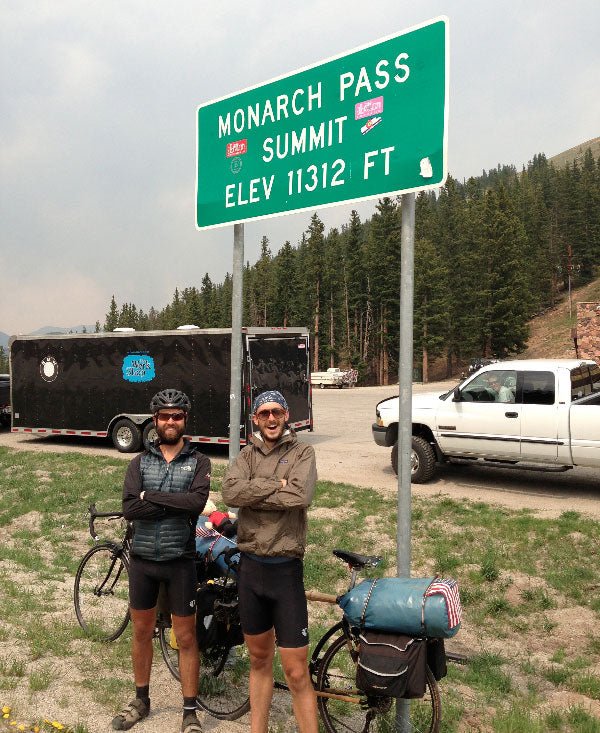Chris, and his friend Andrew, in front of a sign for the the Monarch Pass