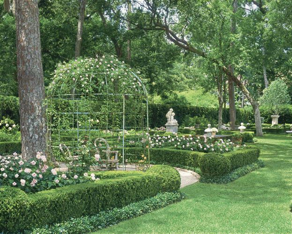 Lush green garden with sculptures and pottery