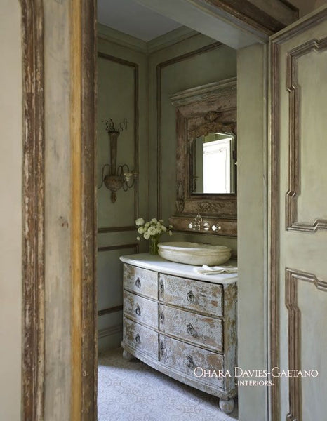 Luxury coastal powder room with antique French mirror
