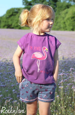 French Terry "Flamingo Love" kombiniert mit Jersey "Basic Love", sowie Zackenlitze & Klöppelspitze "Samara" genäht wurde das eBook - "# 40 deine Helma Kids" - Kleid/Shirt kombiniert mit der Hose "Suri Kids" von meine Herzenswelt  - kurze Hose - Shorts - Plotterdatei "Flamingo" - Nähen/Plotten - Kinder/Mädchen - Stoff & Schnitt - Glückpunkt.