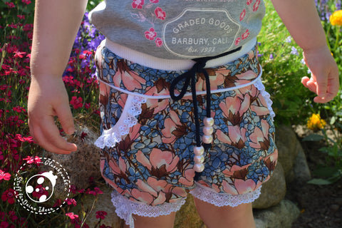 Cupro-Satin "Florence" - Blumen kombiniert mit Rüschenband "Amira", sowie Jersey-Paspel "Mimo", Baumwoll-Kordel "Hanni" und Perlen genäht wurde  das eBook - "Tuula Shorts" - Meine Herzenswelt - kurze Hose - Nähen für Kinder - Mädchen - Frühling/Sommer - Schnittmuster & Stoff - Glückpunkt.