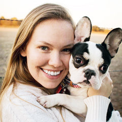 Woman holding her deaf black pied french bulldog