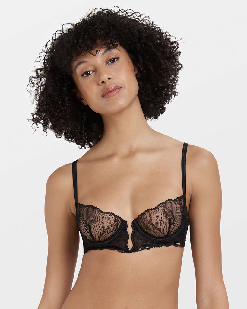 Model wearing Irena black bra with sheer embroidered mesh cups and underwire support.