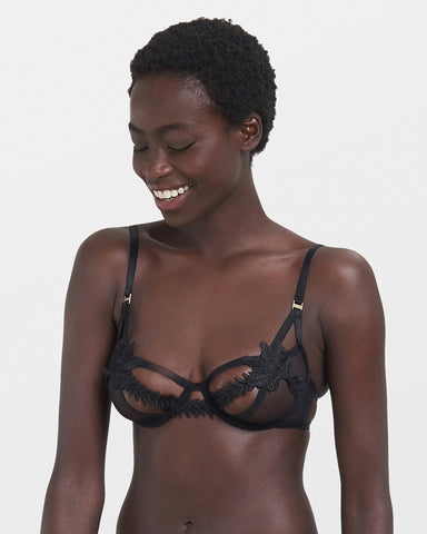 Model looking happy whilst wearing Lennon black mesh bra, a caged and underwired bra to make you feel effortlessly sexy.