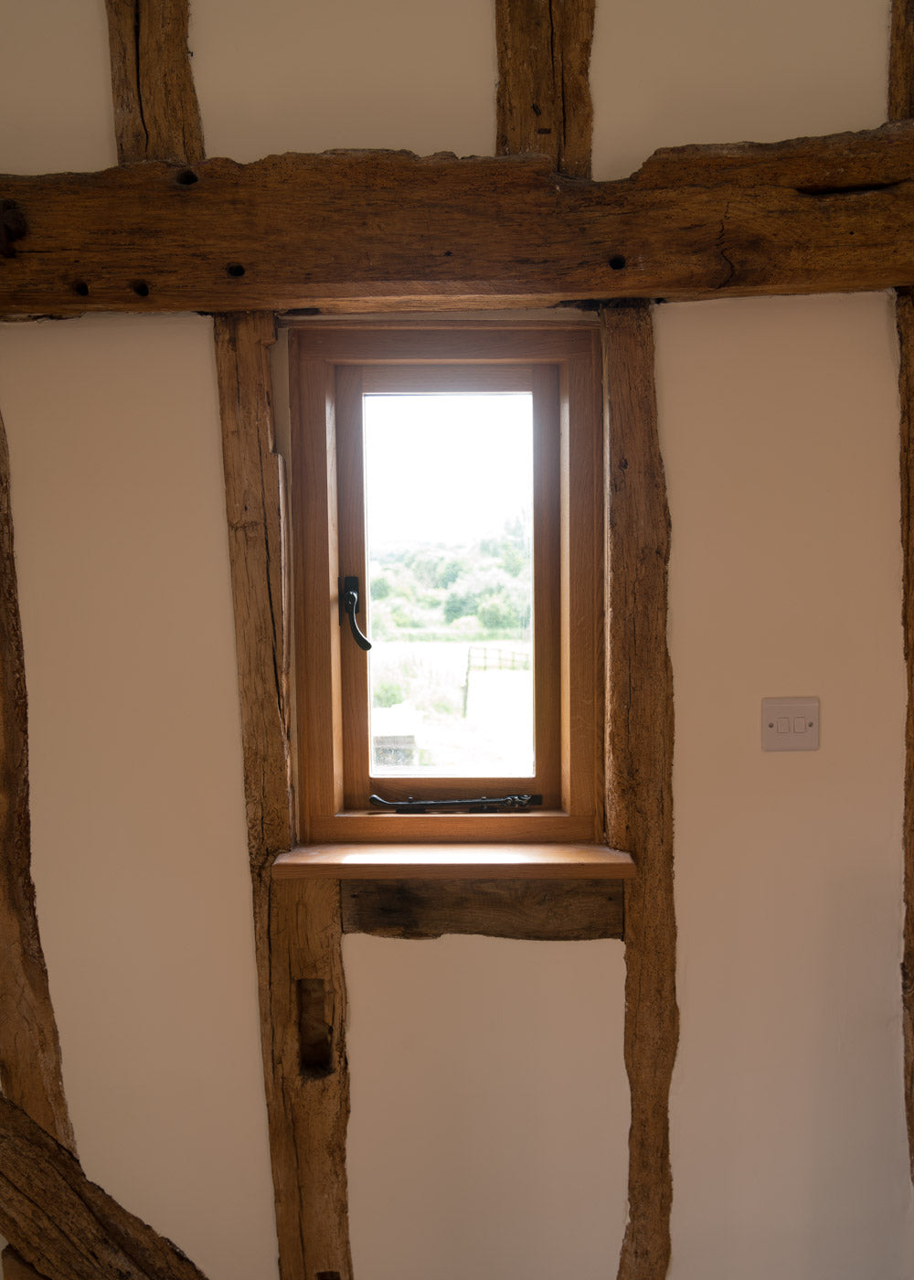 Interior detail of wall and window with black cast iron window hardware