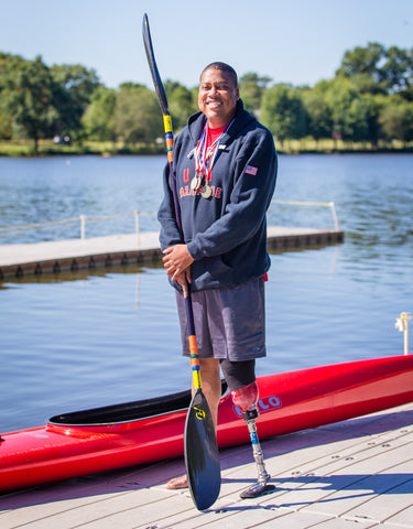 Brandon with his kayak, wearing his medals