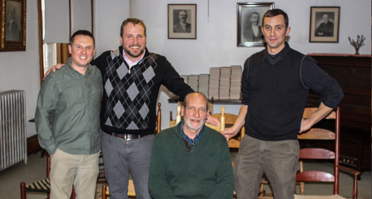 Left to right: Michael Graham, director, United Society of Shakers; Nate Gobeil, Chilton Furniture; Brother Arnold Hadd (seated in the Alfred Side Chair prototype); Adam Nudd-Homeyer, Tappan Chairs. Photo: Sean Hurley