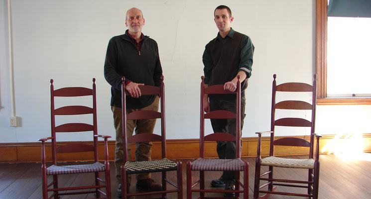 Brother Arnold Hadd and Adam Nudd-Homeyer with the original and “new generation” of Alfred Chairs. Photo: United Society of Shakers