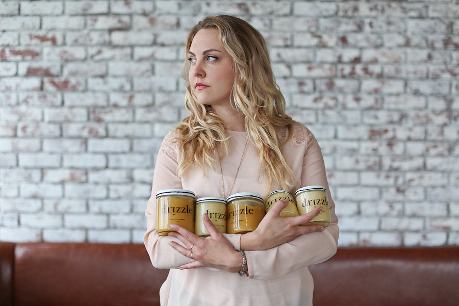 Drizzle Honey Founder Aja Horsley Posing with jars of raw Canadian honey