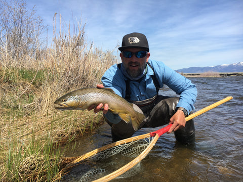 Brian Rosenberg posing with a brown trout caught on the Madison River during a guided float fishing trip near Ennis Montana