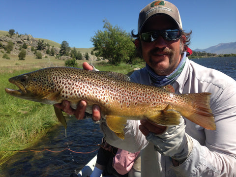Outfitter Brian Rosenberg posing with a brown trout caught during the salmon fly hatch on the Madison River near Ennis Montana
