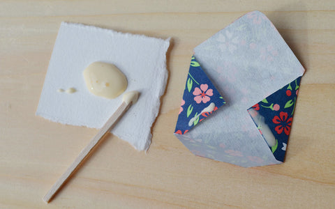 Applying glue to homemade Valentine's envelopes