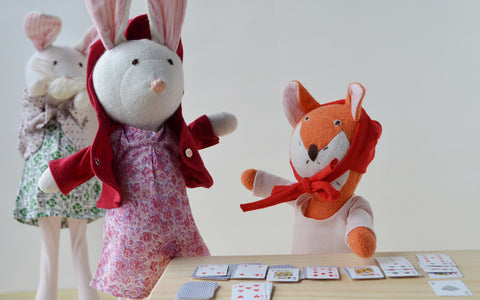 Flora Fox playing cards near Penelope and Emma Rabbit