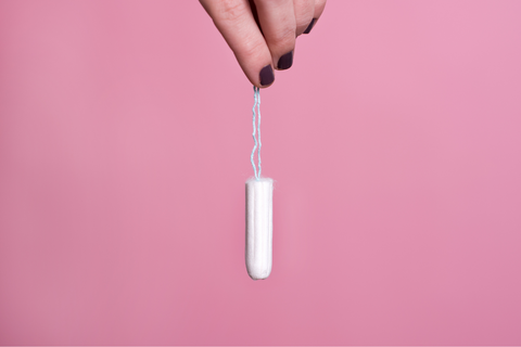 Close up of a woman holding a toxic tampon
