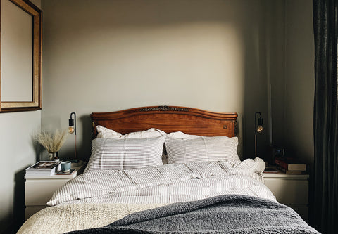 a vintage bed with grey stripe linen duvet cover and pillow cases 