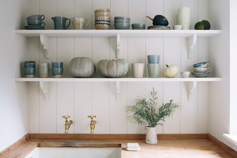 White shelves with blue and green pottery