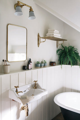 Wood panelled bathroom with black bath