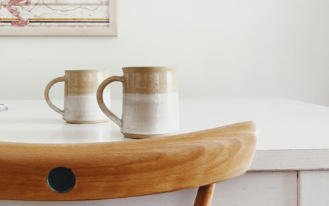 Two two-tone cream mugs on a white table
