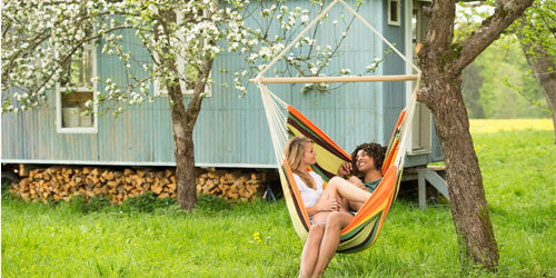 Man and woman sat in hanging hammock chair