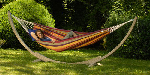 Woman lying in hammock on a wooden stand