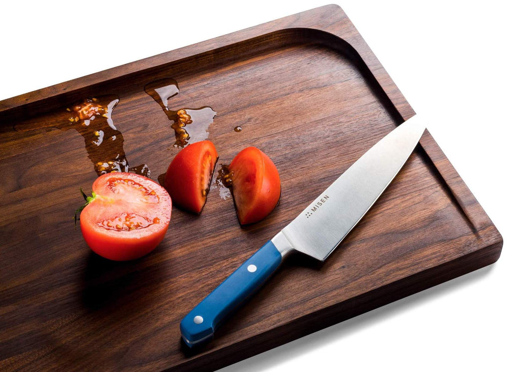 How to clean a wooden cutting board: Sliced tomato, knife, and cutting board