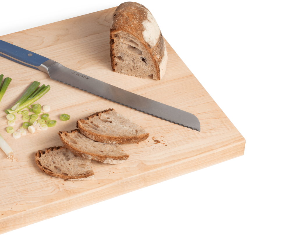 How to sharpen a serrated knife: a serrated knife on a cutting board with sliced bread