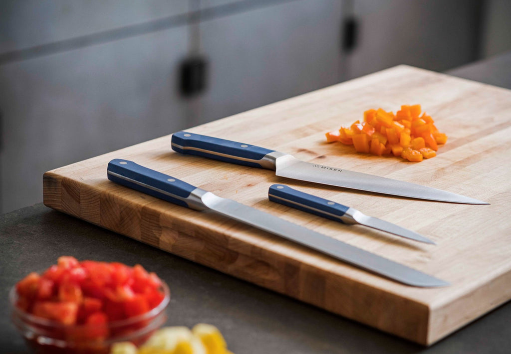 Knife cuts: three knives on a cutting board with fine diced vegetables