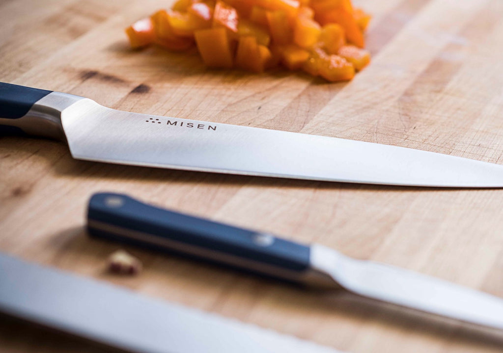 How to cut a papaya: three knives on a cutting board next to diced papaya