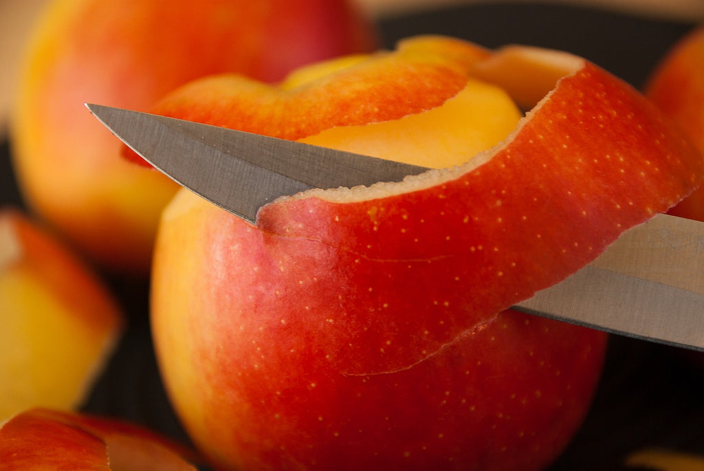 How to sharpen kitchen knives: a paring knife peels an apple