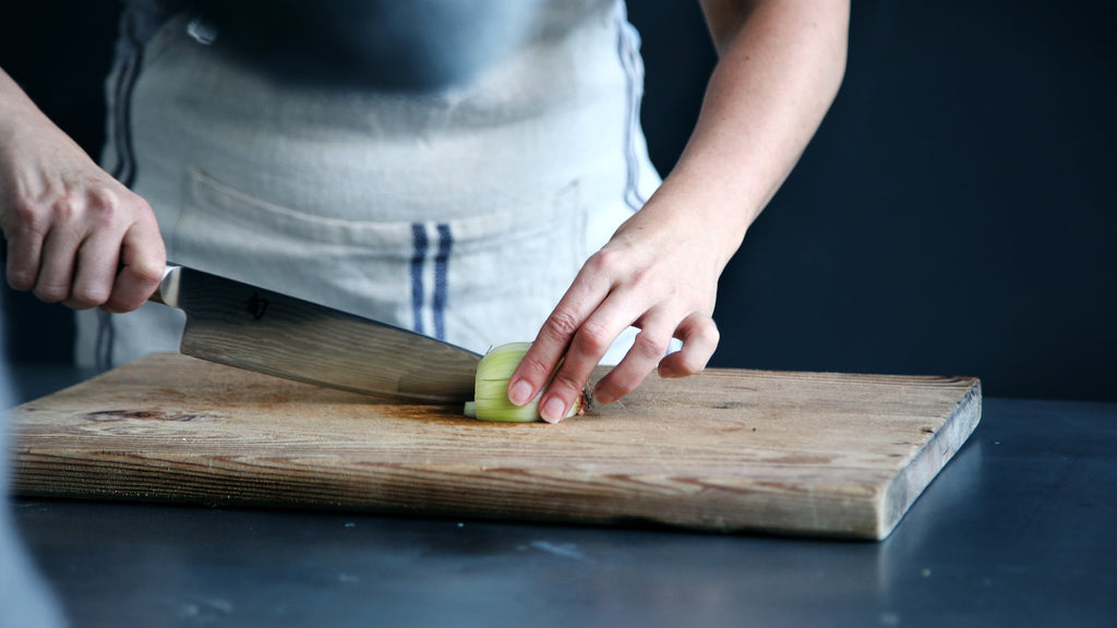 Chefs knives: A man chops an onion