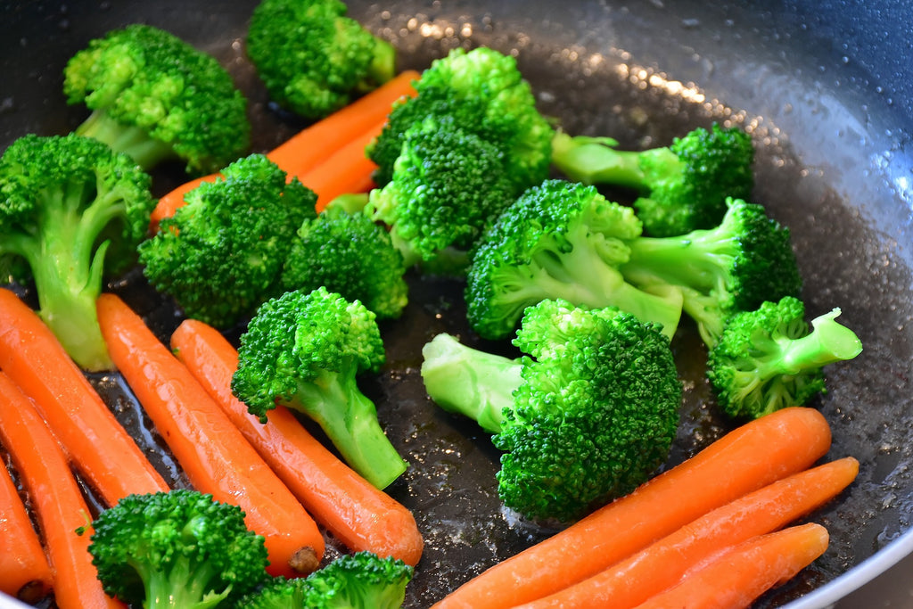 Carrots and broccoli being sautéd