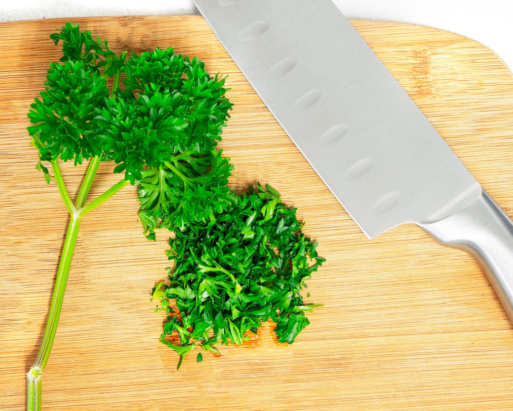 Full tang knife: a knife on a cutting board with parsley