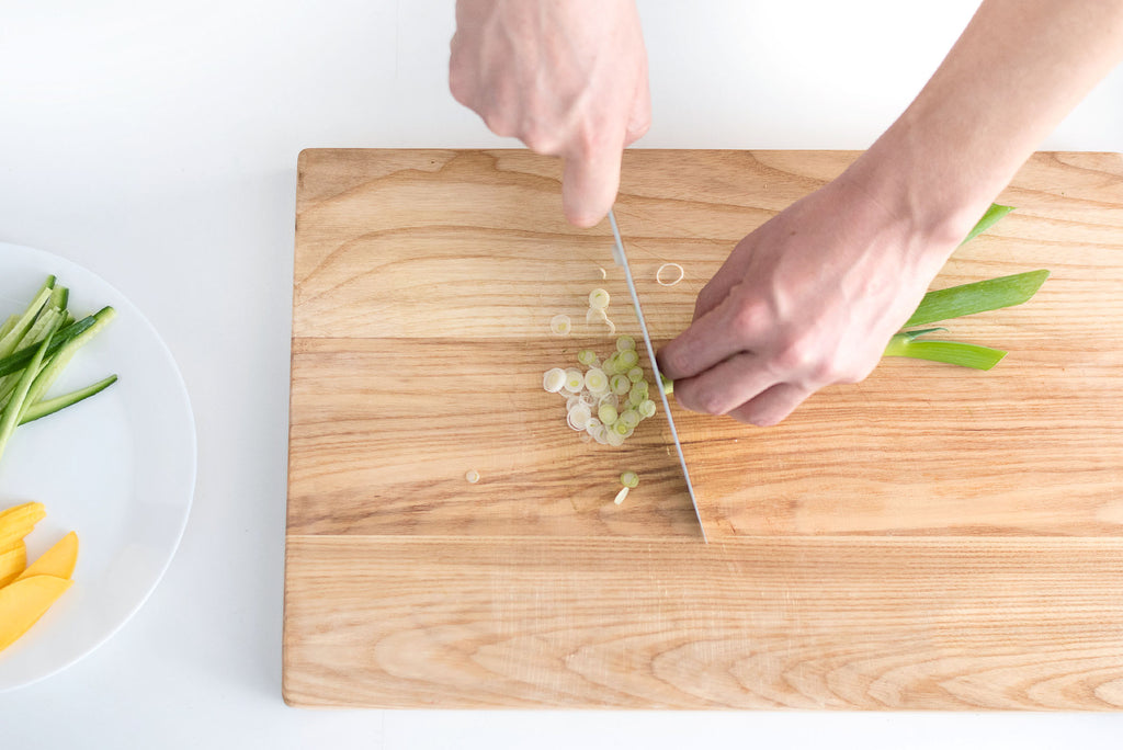 The Best Cutting Board Oil: slicing a scallion on a cutting board