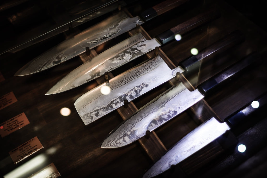 Japanese kitchen knives: a collection of Japanese knives with a petty knife closest to the frame