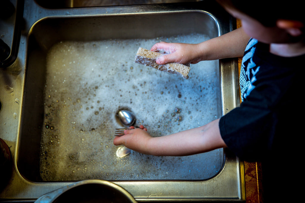 How to cook with stainless steel: Hands wash dishes in the sink