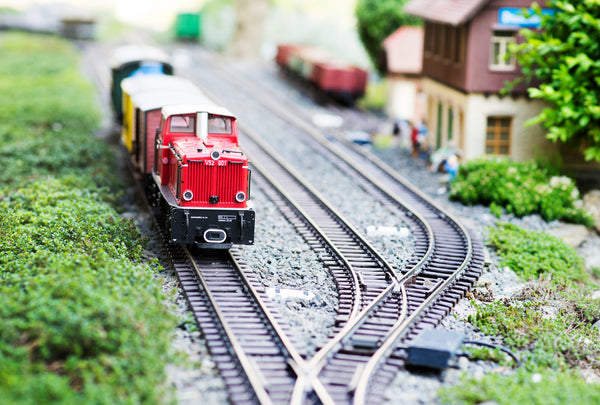 Model train layout with red engine car on the tracks