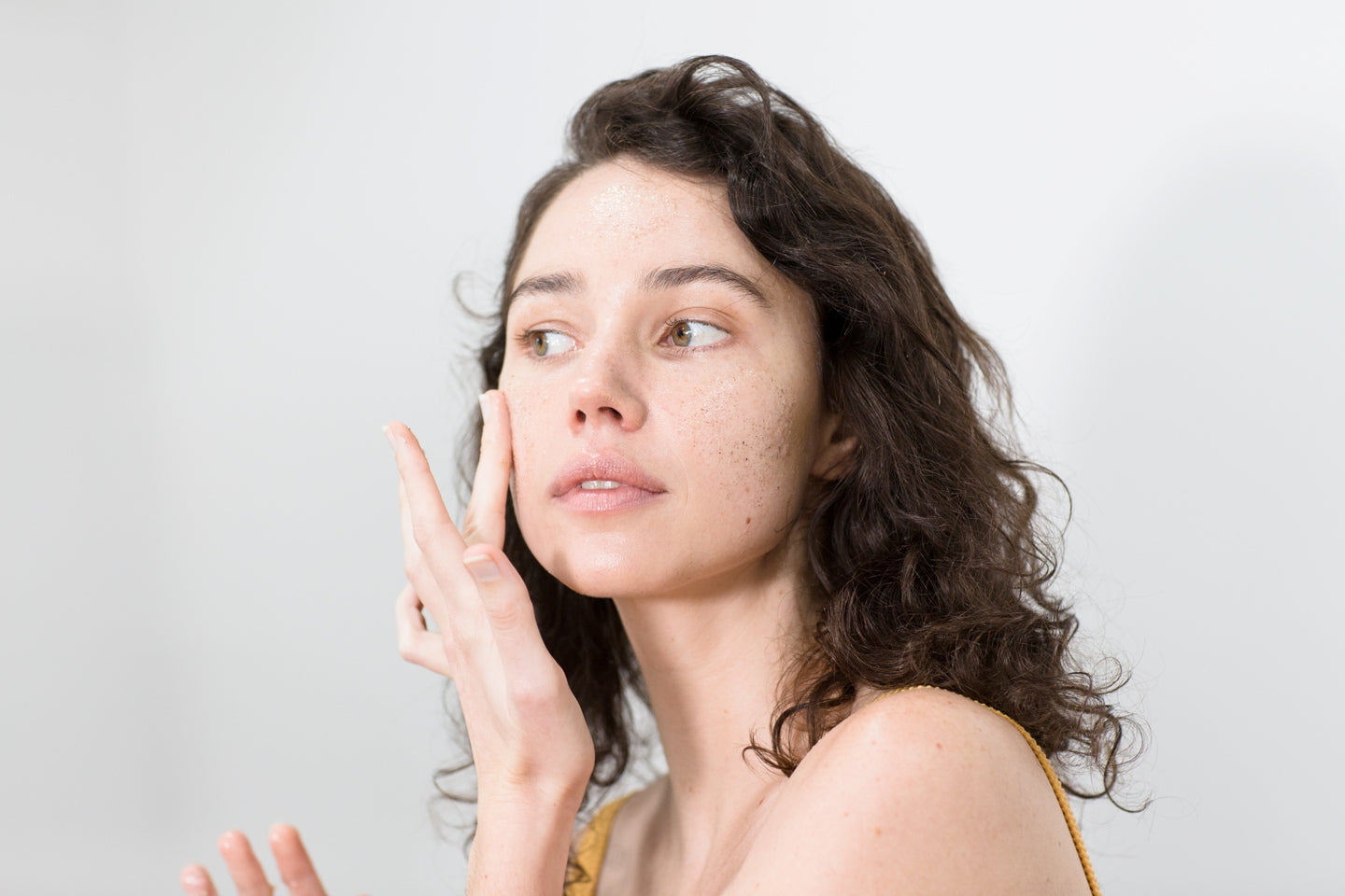 Young woman applying Be Fraiche Smooth and Glow Exfoliator on her face