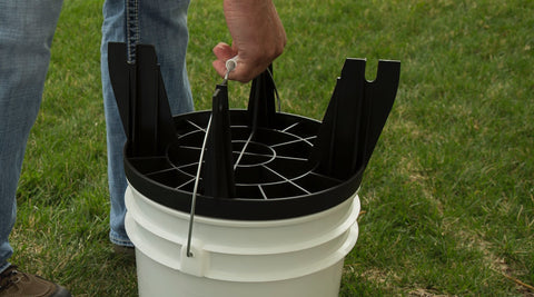 Person carrying bucket by the handle and using The Original Bucket Stool™ upside down as a lid. Click to see convenience solutions page.