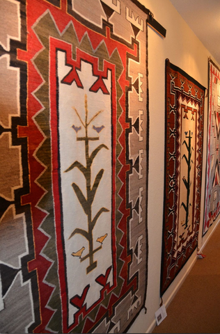 Tree of Life Native American Rug with Teec Nos Pos elements hanging at the Nizhoni Ranch Gallery