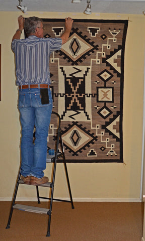 Steve Getzwiller hanging Two Grey Hills Navajo rug