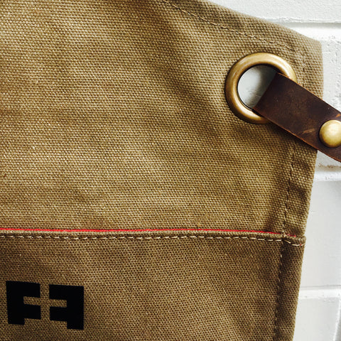 waxed cotton canvas apron detail with grommet and veg tan leather strap