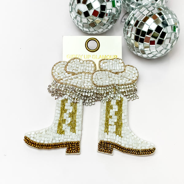 Beaded White, and Gold Cowboy Boot Earrings with White Hat Studs. Pictured on a white background with disco balls in the top right corner.